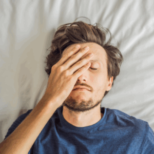 En mand der ligger i sengen men stadig er meget træt